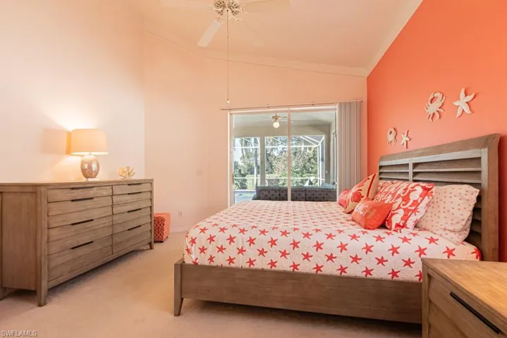 Bedroom with crown molding, light colored carpet, vaulted ceiling, ceiling fan, and access to exterior