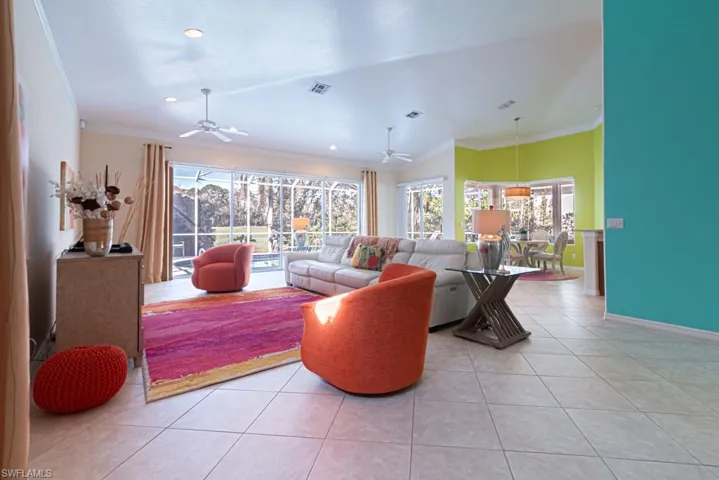 Tiled living room featuring crown molding and ceiling fan
