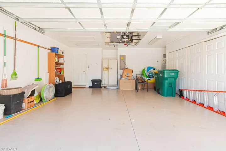 Garage featuring white fridge with ice dispenser