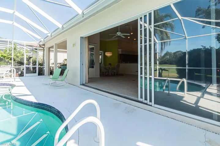 View of swimming pool with ceiling fan, a lanai, and a patio area