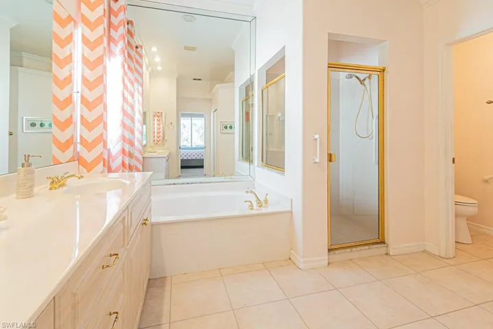 Full bathroom with ornamental molding, plus walk in shower, tile patterned flooring, and vanity