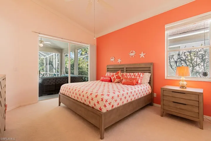 Carpeted bedroom featuring access to exterior, vaulted ceiling, ornamental molding, and ceiling fan
