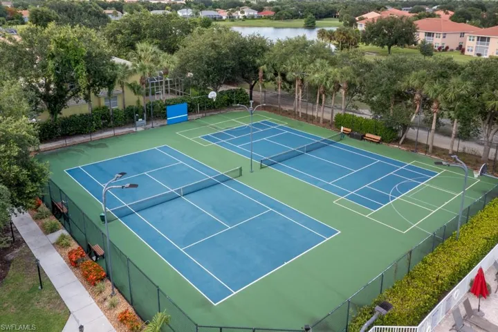 View of tennis court featuring a water view