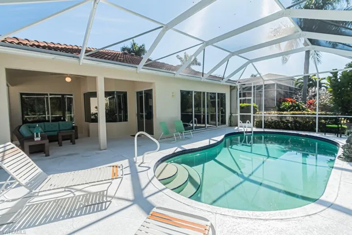 View of swimming pool with a lanai, outdoor lounge area, and a patio