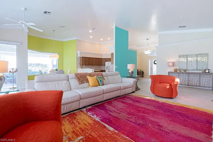 Living room featuring crown molding and light tile patterned flooring