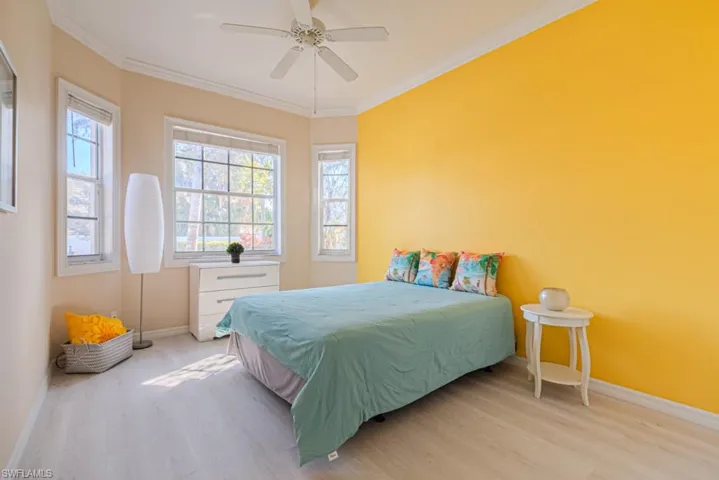 Bedroom featuring ornamental molding, ceiling fan, and light hardwood / wood-style floors