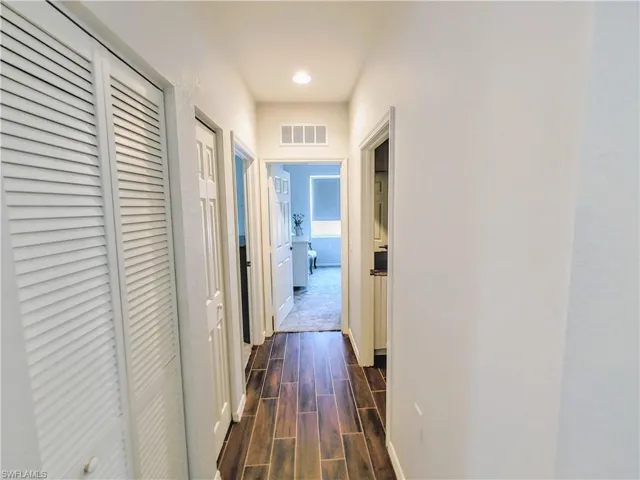Hall with dark hardwood / wood-style floors