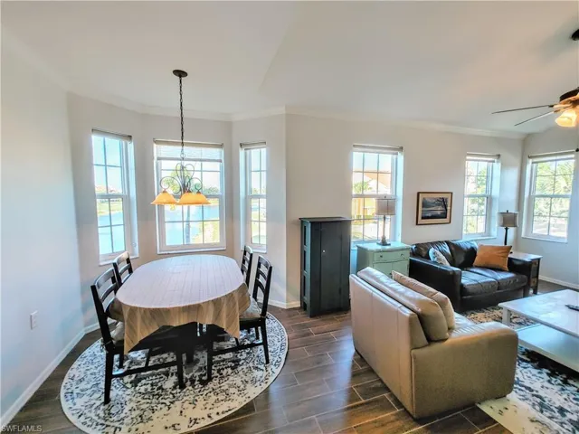 Living room with crown molding, dark hardwood / wood-style floors, and ceiling fan