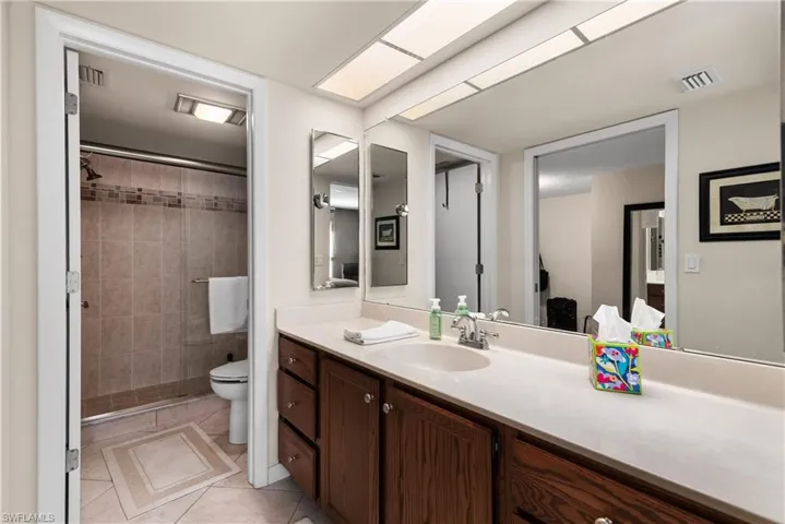 Bathroom with vanity, light tile patterned floors, and a shower stall