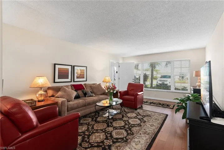 Living room featuring wood-type flooring and a textured ceiling