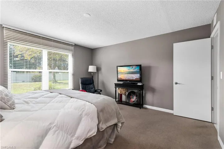 Carpeted bedroom with baseboards and a textured ceiling
