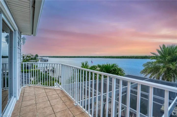 Balcony at dusk featuring a water view - Virtually Edited Image