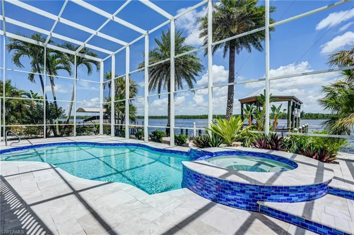 Relaxing pool / spa with a lanai, a patio, and a water view - Virtually Edited Image