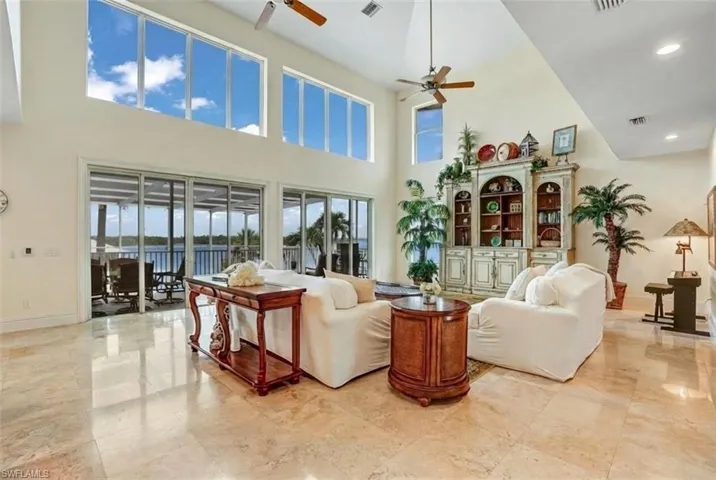 Living area featuring a high ceiling and ceiling fan - Virtually Edited Image