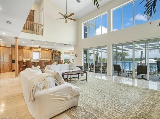Living area with a ceiling fan, a high ceiling, and recessed lighting - Virtually Edited Image