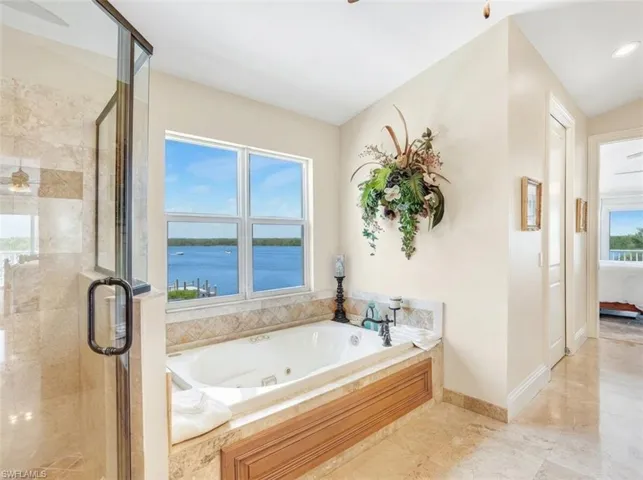 Bathroom with a ceiling fan, a stall shower, connected bathroom, and a tub with jets - Virtually Edited Image