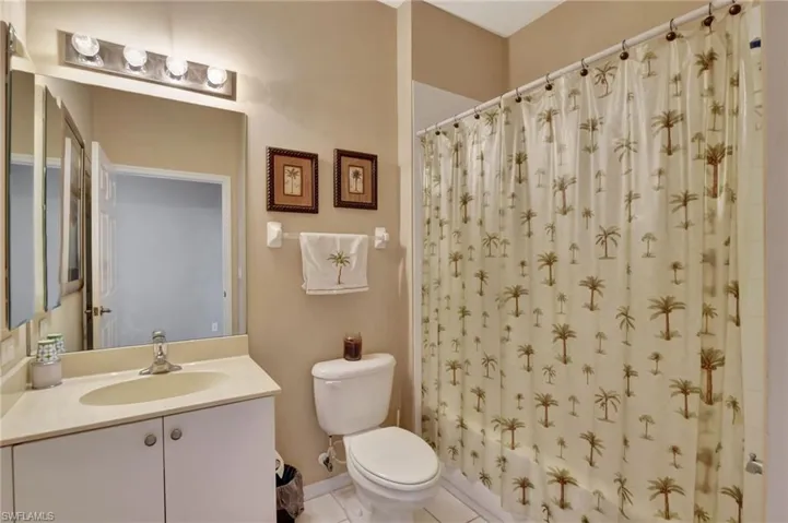Bathroom featuring vanity, light tile patterned flooring, and a shower with shower curtain