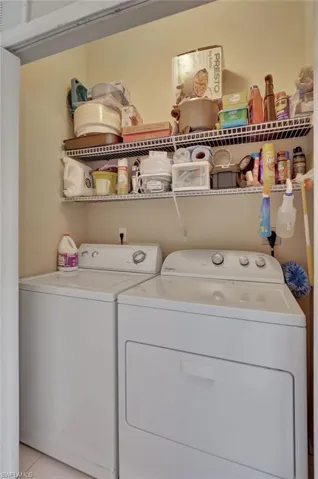 Laundry area featuring separate washer and dryer and light tile patterned flooring