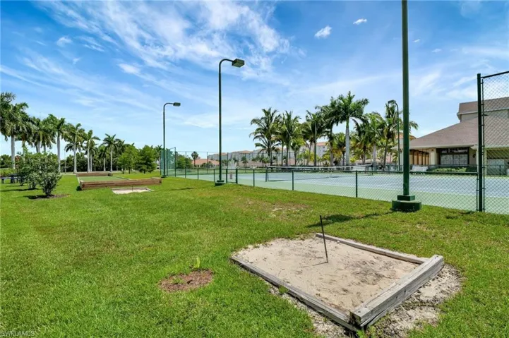 View of home's community with a tennis court