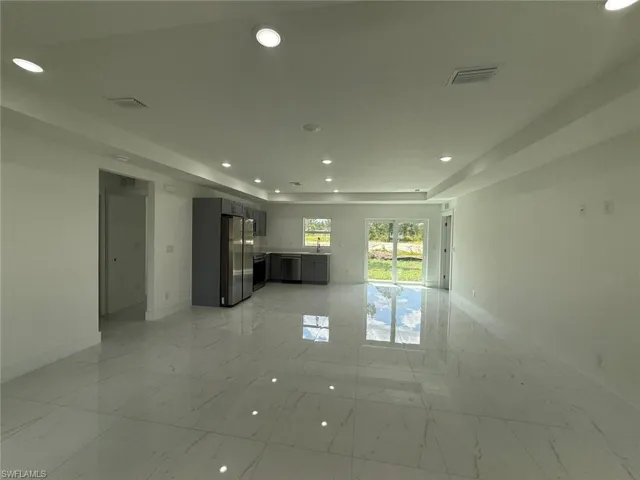 Unfurnished living room featuring recessed lighting and light marble finish flooring