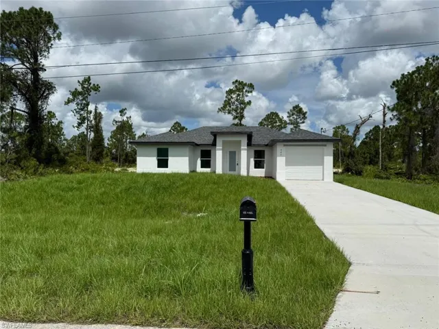 Prairie-style home featuring a garage, driveway, and stucco siding