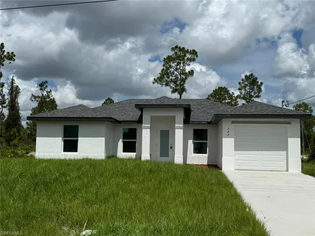 Prairie-style home featuring stucco siding, concrete driveway, a garage, and a shingled roof
