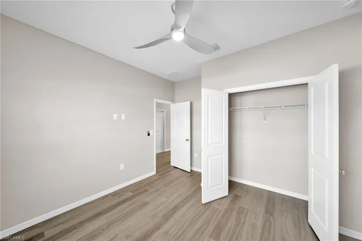 Unfurnished bedroom with hardwood / wood-style flooring, a closet, and ceiling fan
