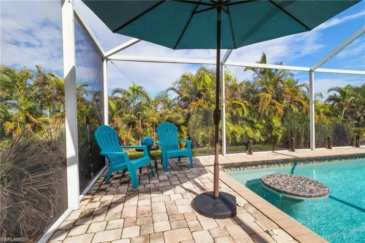 Privacy areka palms, and paver tiles around pool.