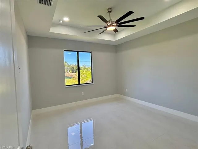 Unfurnished room featuring baseboards, recessed lighting, a raised ceiling, visible vents, and ceiling fan