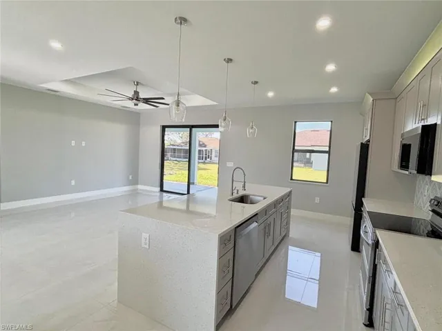 Kitchen with appliances with stainless steel finishes, recessed lighting, a kitchen island with sink, ceiling fan, and a sink
