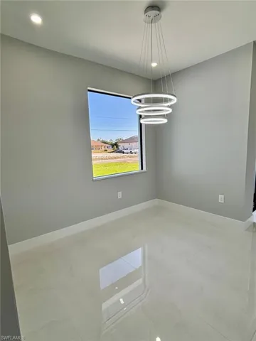 Empty room featuring recessed lighting, a notable chandelier, and baseboards
