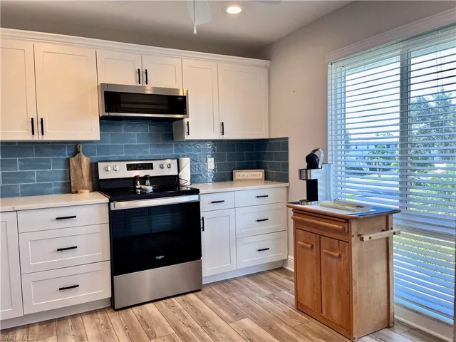 Kitchen featuring ceiling fan, stainless steel appliances, plenty of natural light, and backsplash