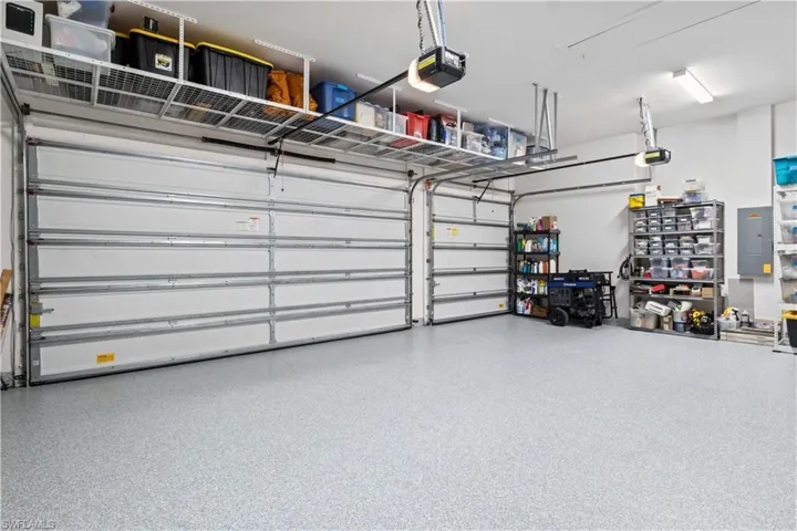 Three car garage with step down ladder and plenty of attic space storage!  Epoxied and additional storage shelving!