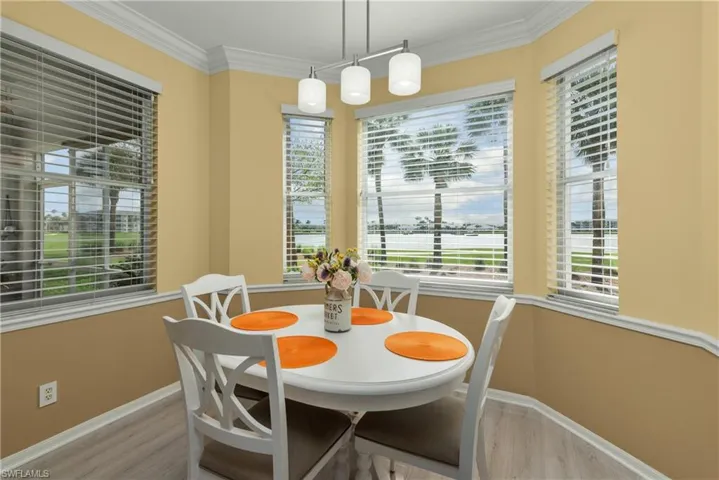 Dining room with ornamental molding and light hardwood / wood-style floors