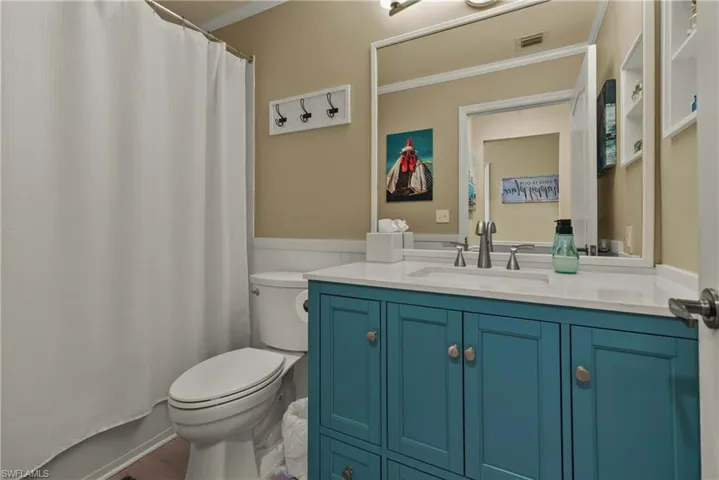Full bathroom with vanity, crown molding, shower / bath combo, and toilet