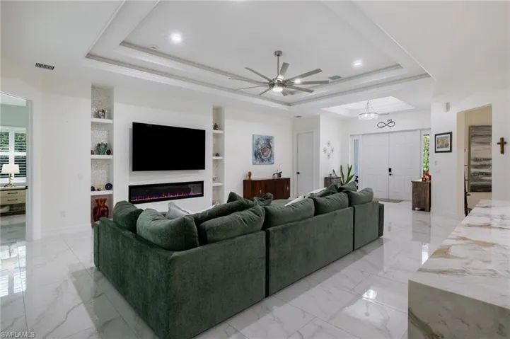 Kitchen featuring stainless steel appliances, white cabinetry, light marble finish flooring, light stone counters, and tasteful backsplash