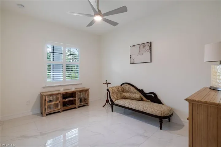 Bedroom featuring light marble finish flooring and ceiling fan