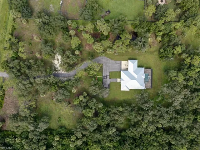 Aerial view of property and surrounding area featuring a heavily wooded area
