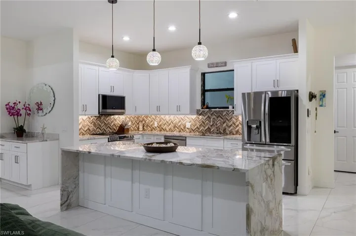 Dining area featuring light marble finish flooring and a chandelier