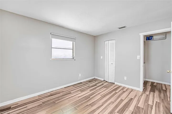 Unfurnished bedroom with wood finish floors and a closet