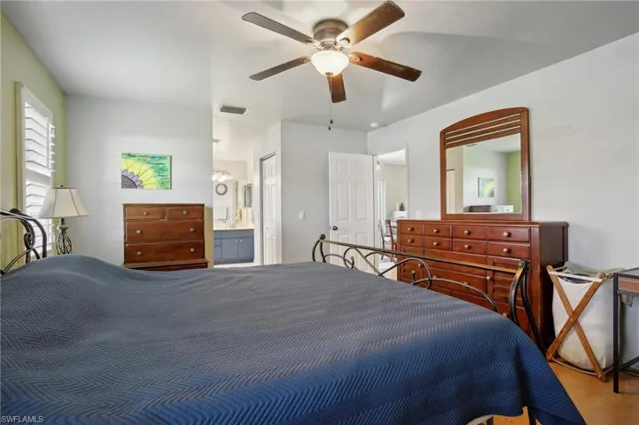 Bedroom with ensuite bathroom, wood-type flooring, and ceiling fan