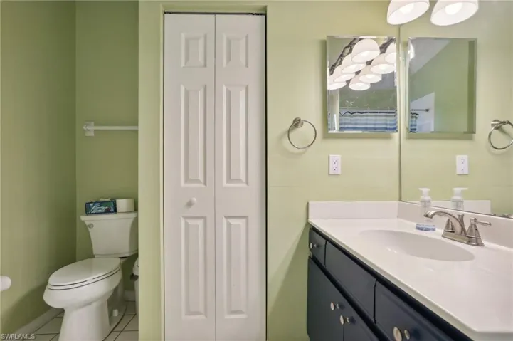 Bathroom featuring vanity, tile patterned flooring, and toilet