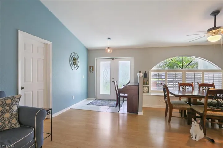 Foyer with french doors, light hardwood / wood-style flooring, ceiling fan, and vaulted ceiling