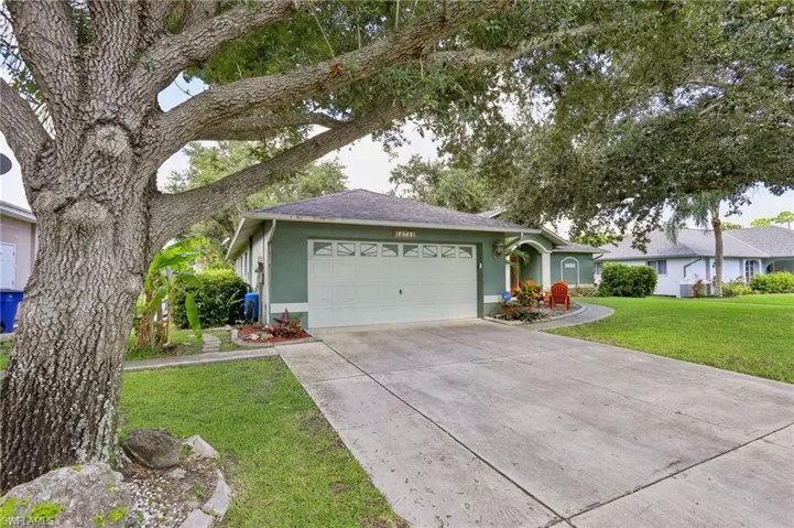 Ranch-style home featuring a garage and a front lawn