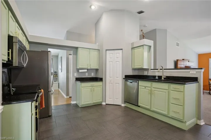 Kitchen featuring green cabinets and stainless steel appliances