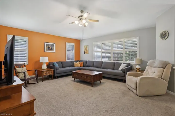 Living room featuring light colored carpet and ceiling fan