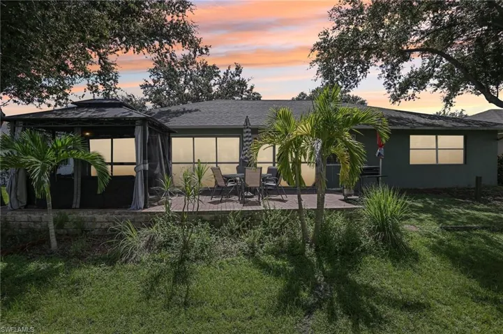 Back house at dusk featuring a patio area