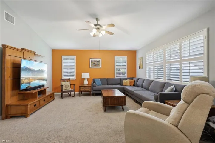 Carpeted living room with ceiling fan