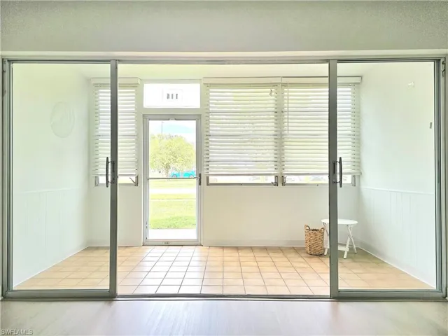 Entryway with wainscoting, tile patterned flooring, and wood walls