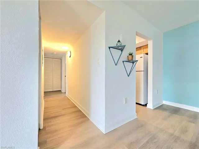 Hall with light wood-type flooring and baseboards